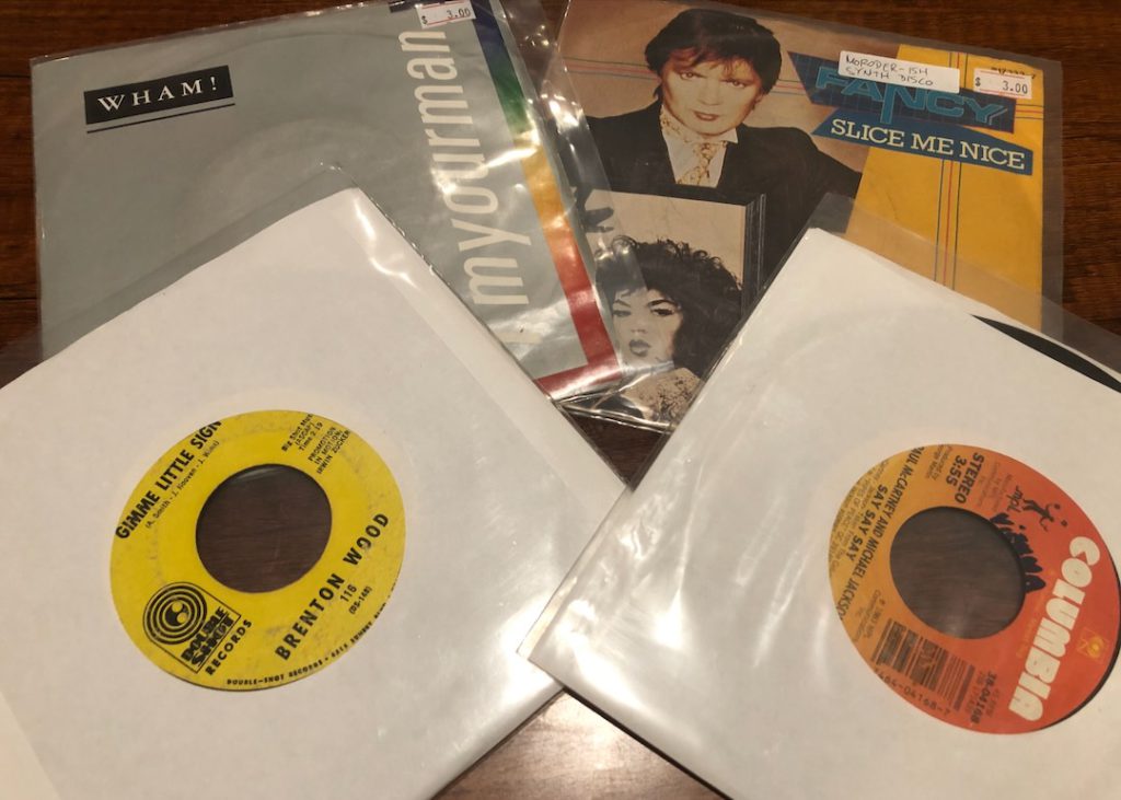 vinyl 45 of Wham "I'm Your Man," Fancy "Slice Me Nice" Brenton Wood "Gimme Little Sign" Paul McCartney and Michael Jackson "Say Say Say"